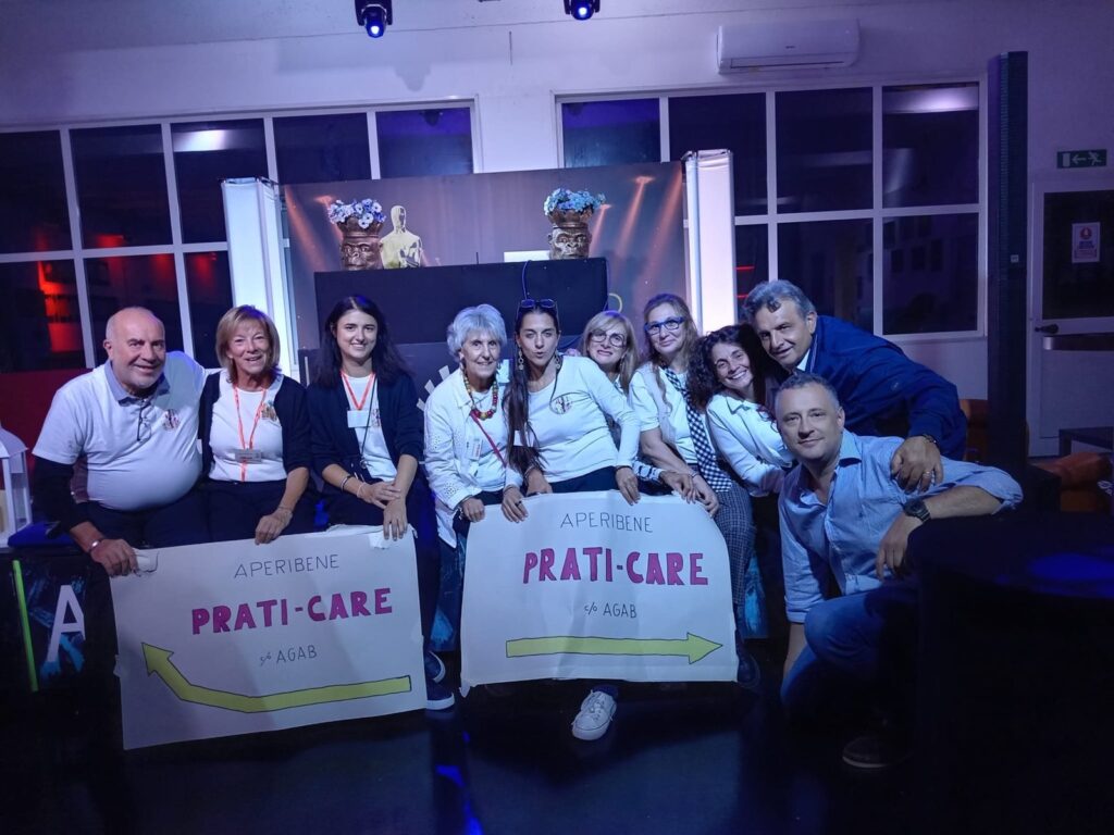 Lo staff di Prati-Care ODV all'AperiBene, con i cartelli dell'associazione