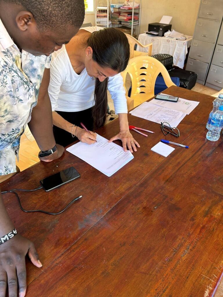 Una volontaria firma l'accordo con la Timboni Sawa Sawa Academy