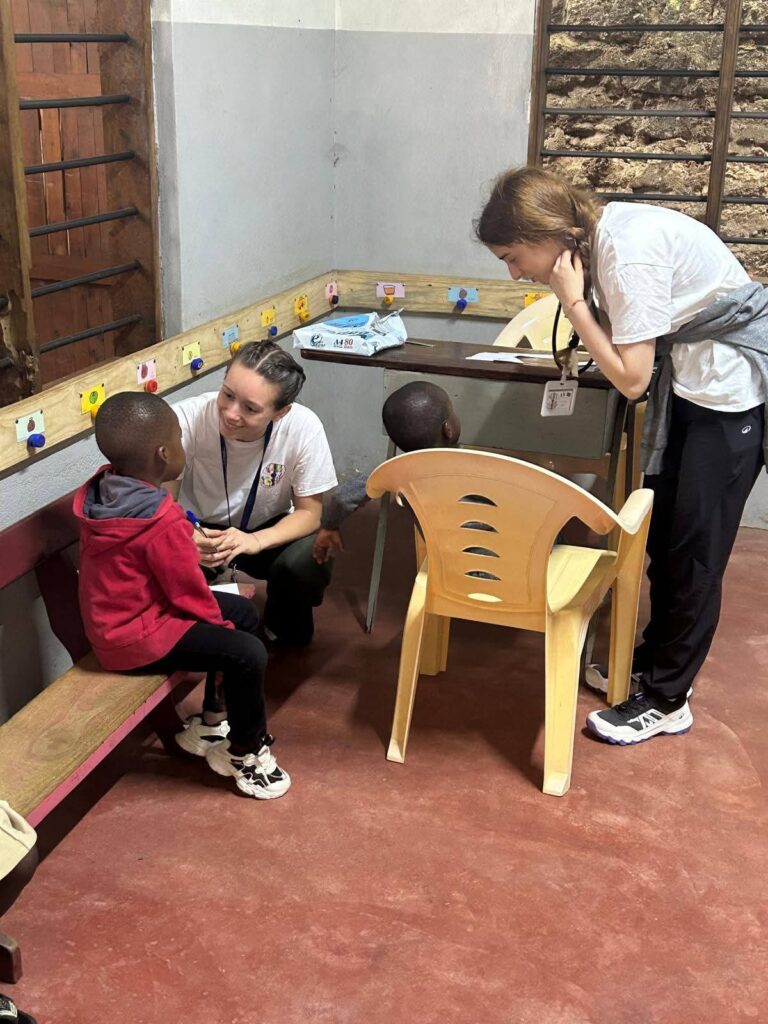 Una volontaria segue un bambino negli esercizi