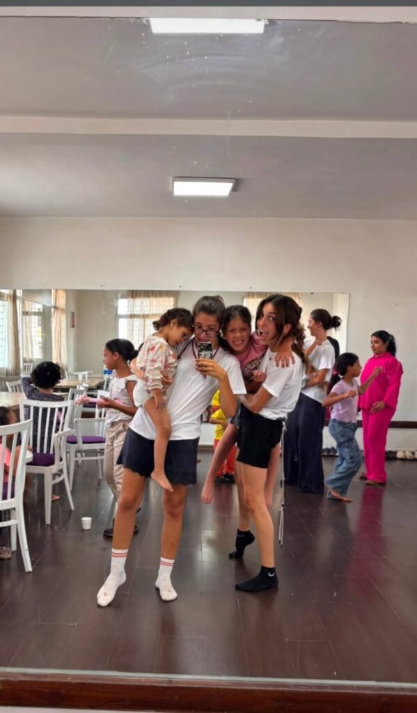 Volontarie e ragazze ballano in una sala