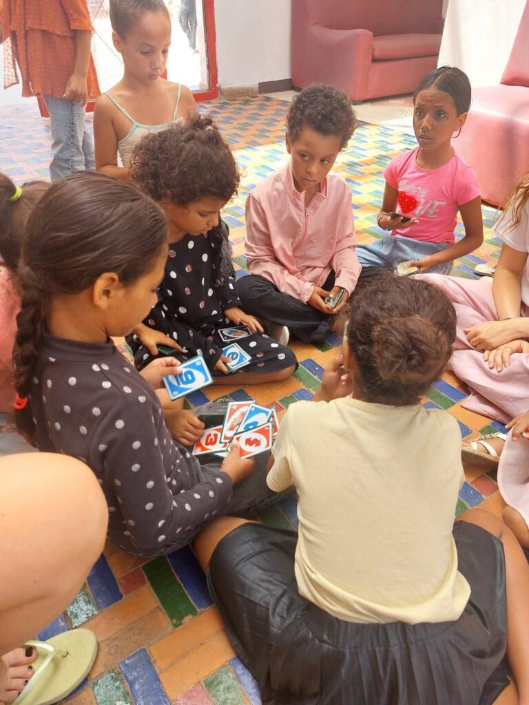 Bambini seduti in cerchio sul tappeto giocano a carte