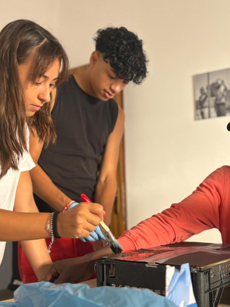 Volontarie e ragazzi dipingono durante un laboratorio