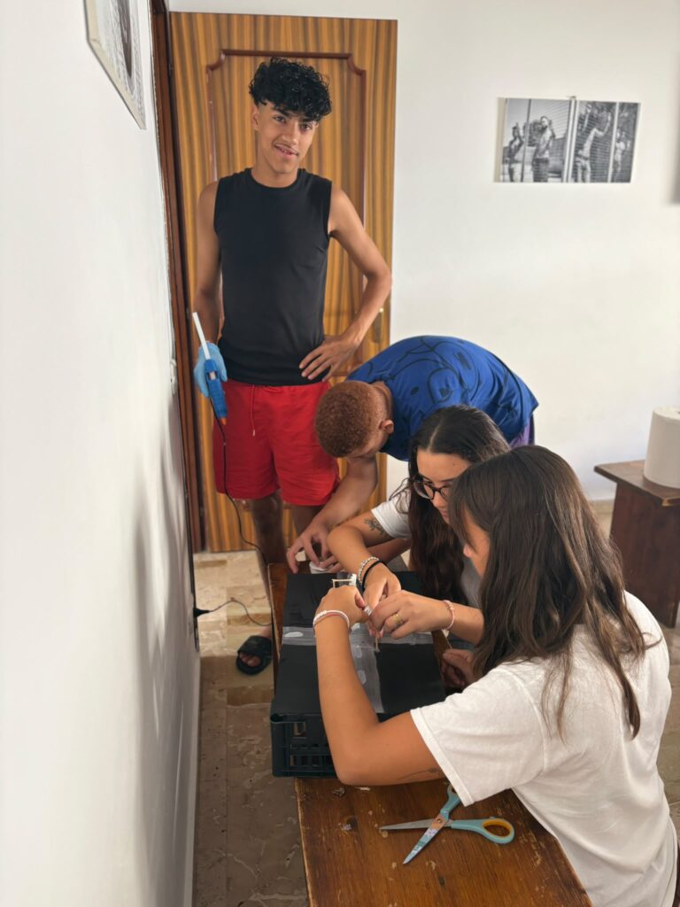 Volontarie e ragazzi dipingono durante un laboratorio
