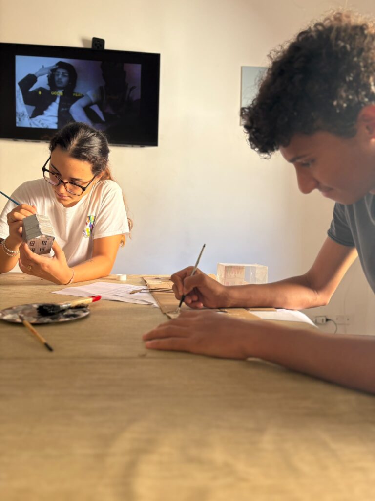 Volontarie e ragazzi dipingono durante un laboratorio