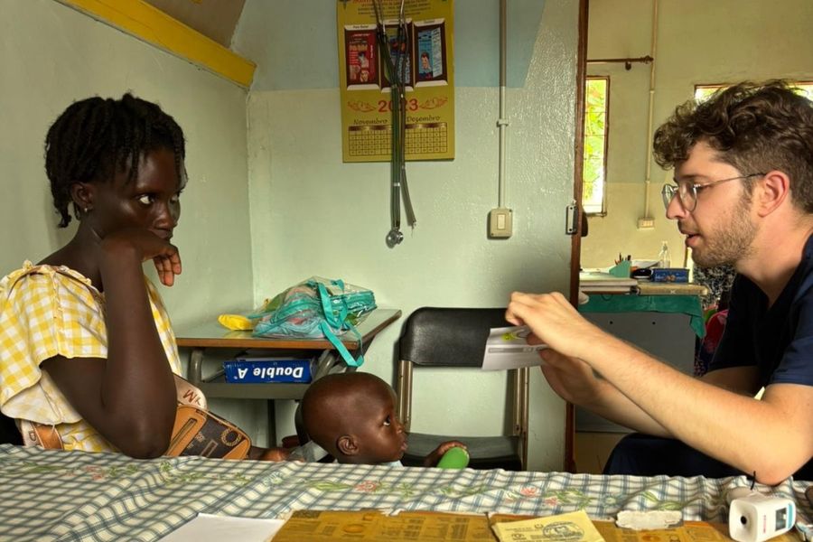 Un volontario parla con una mamma e il suo bambino in ambulatorio