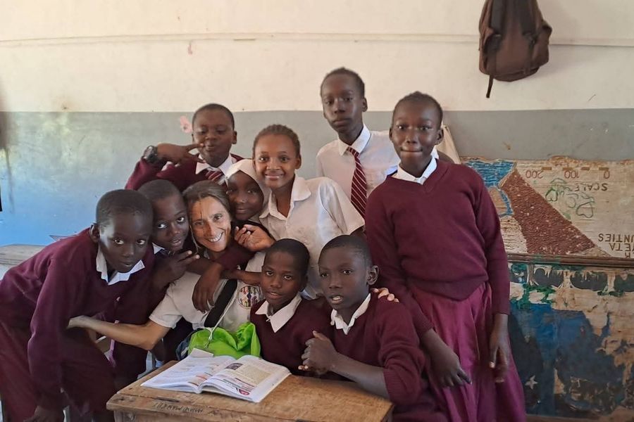 Una volontaria in classe, circondata da alunni in divisa