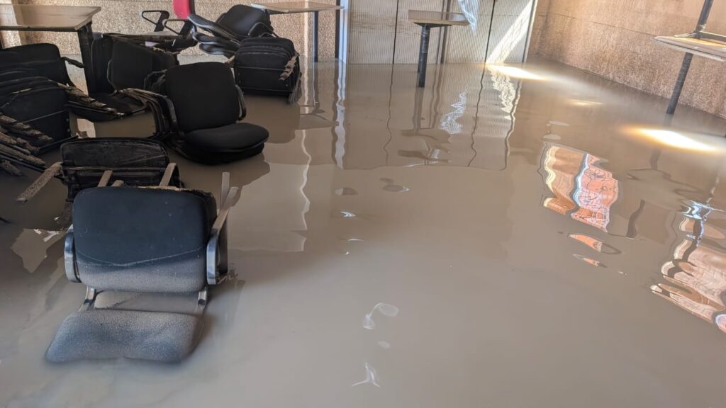 Sedie da ufficio sommerse in un corridoio allagato